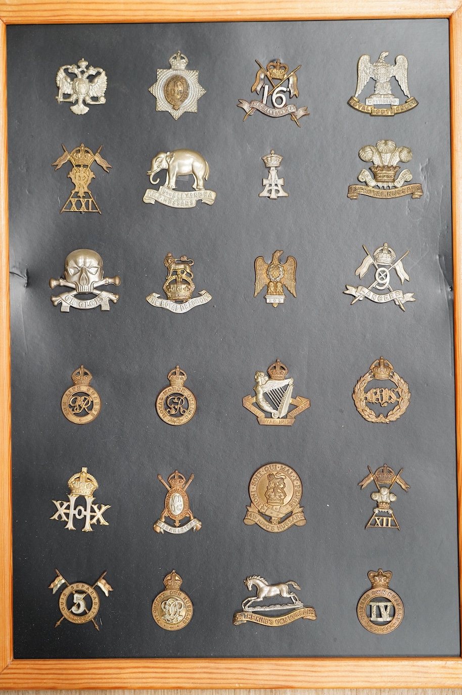 A collection of ninety-five military cap badges mounted on four boards including; The Reconnaissance Corps, RAEC, Royal Engineers, Small Arms School, Royal Warwickshire 1st Birmingham Battalion, Royal Army Medical Corps,